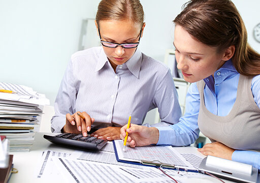 Concentrated business women reviewing accounting report